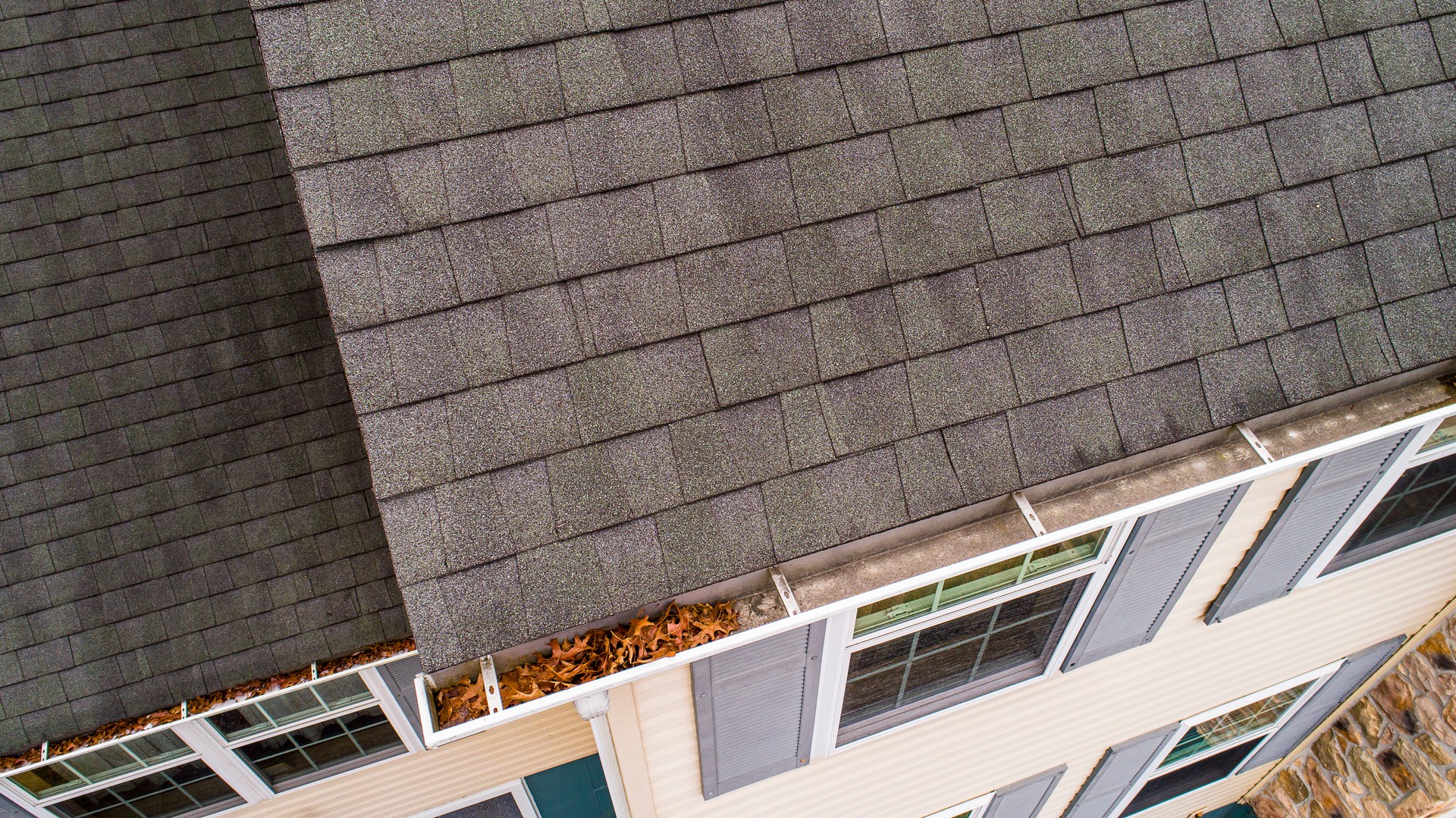 Inspection of roof shingles and gutters from drone in autumn.